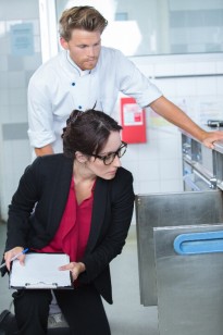 Inspectrice contrôlant le respect des règles d'hygiène dans le frigo d'un restaurant